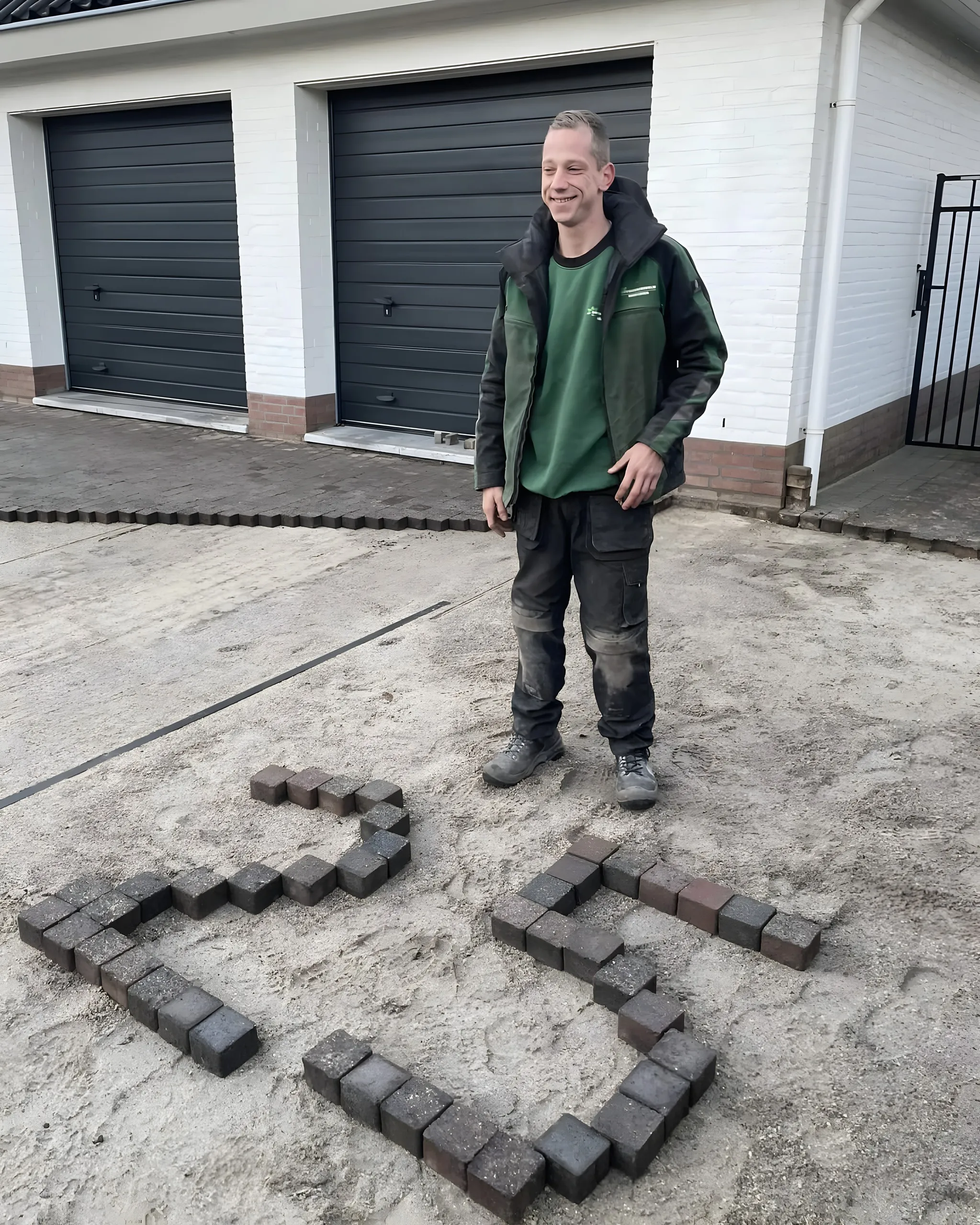 Bas Hennissen in werkkleding op een vers zandbed, bij een 23 van klinkers