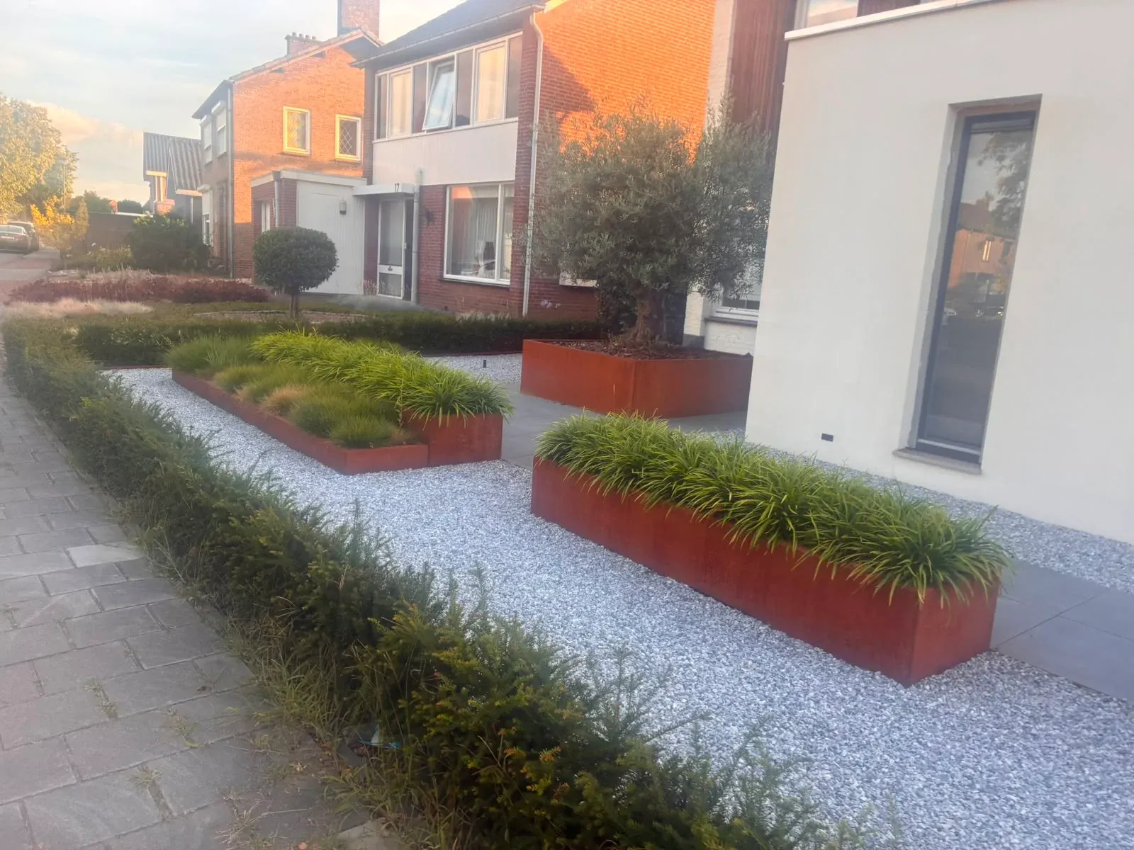 Cortenstalen borders met siergrassen in een moderne voortuin