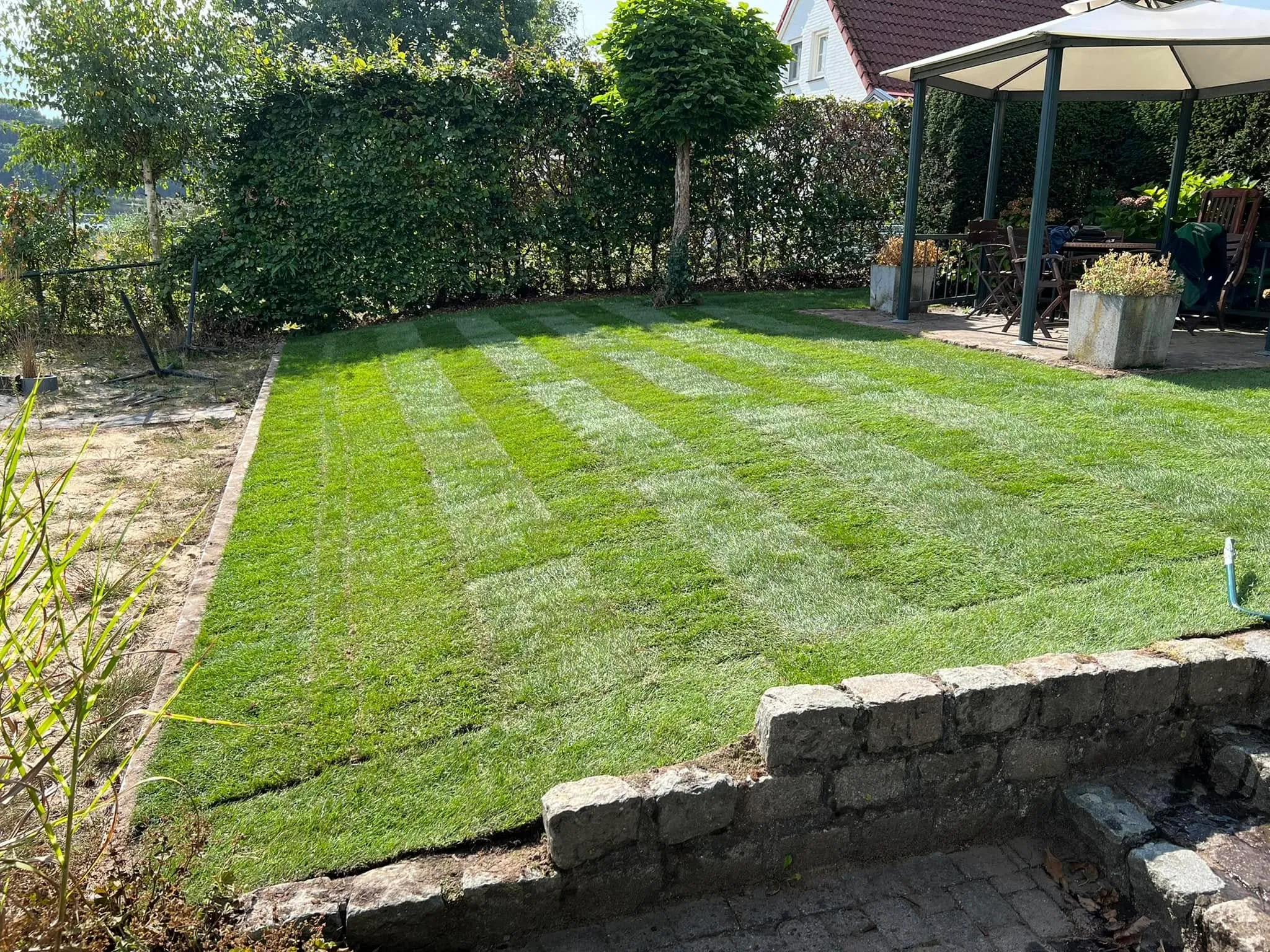Gestreept gazon in een tuin aan het water