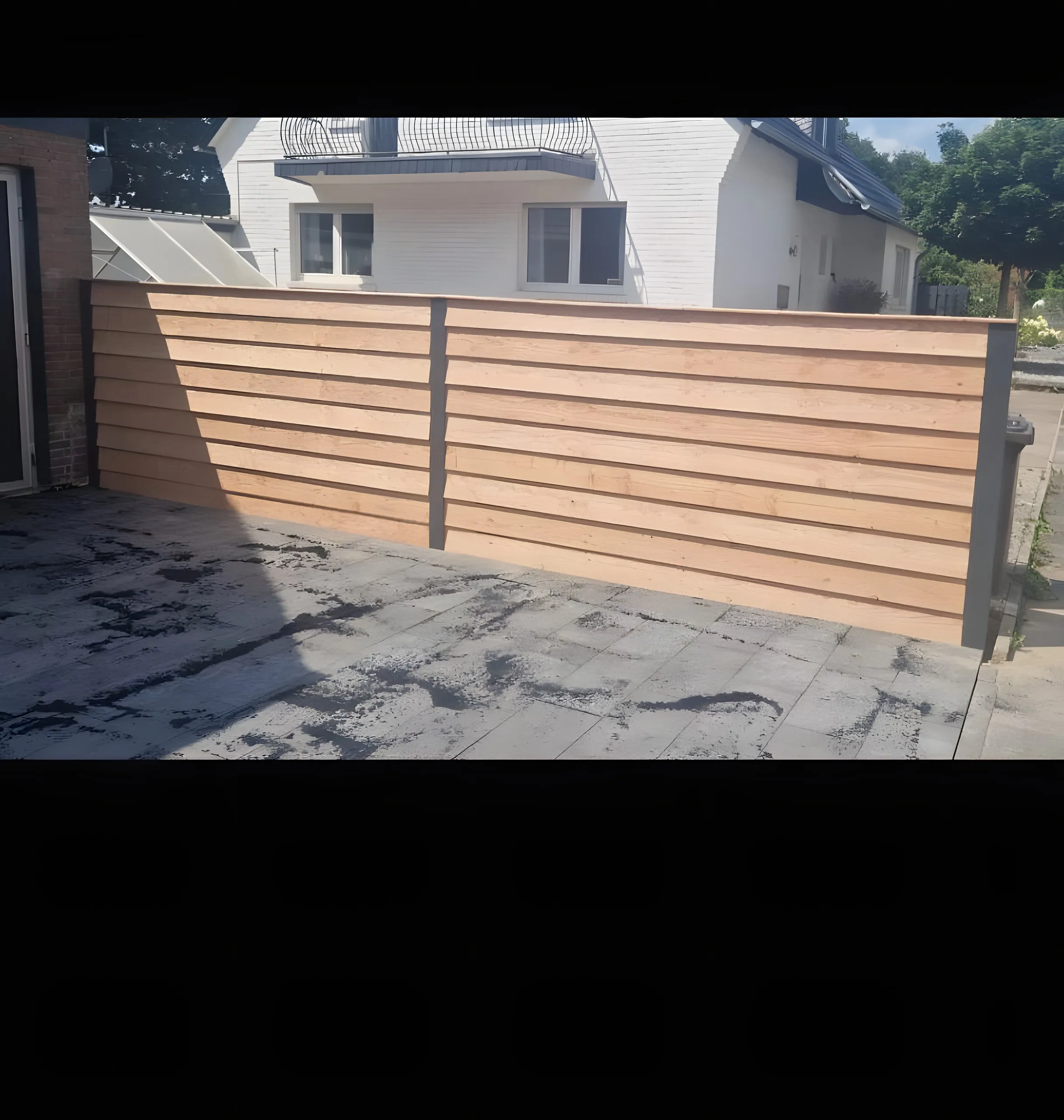 Nieuwe horizontale schutting bij een antraciet terras