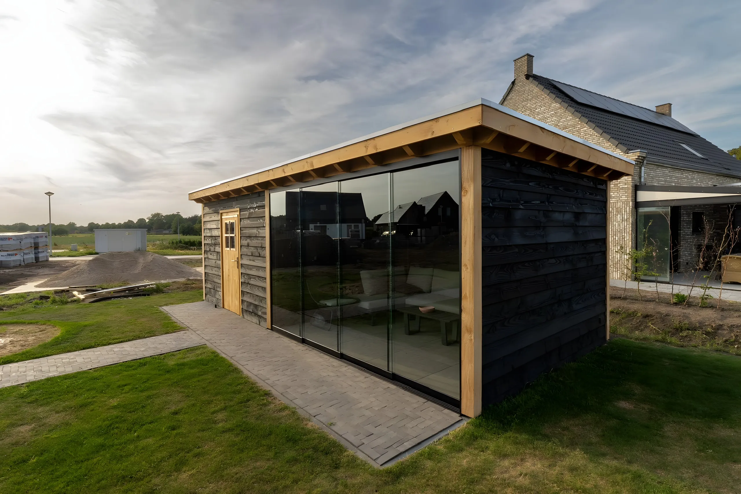Tuinhuis met glazen pui op vers gazon