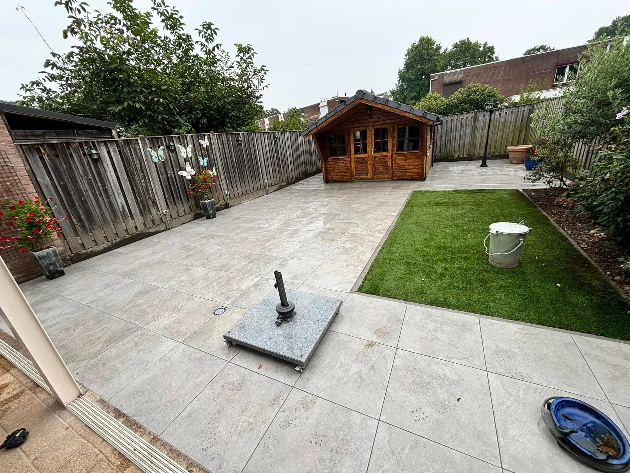 Houten tuinhuis met nieuw terras en gazon