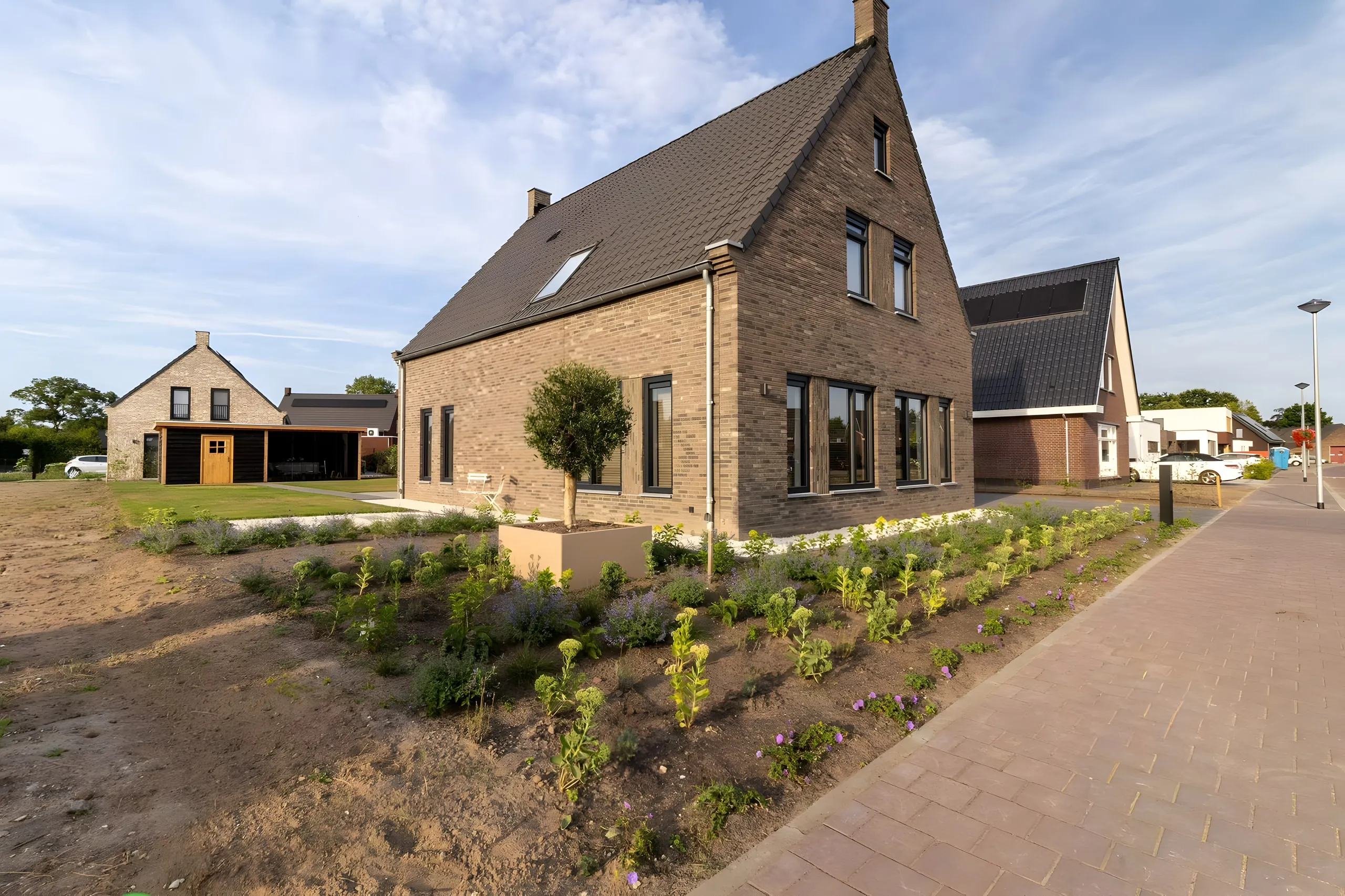 Voortuin met jonge aanplant rond de woning